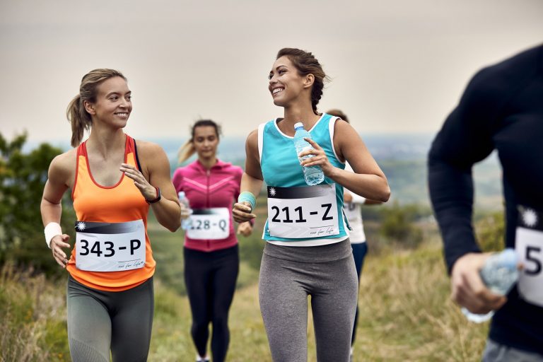 Young happy athletic women running a marathon in nature.