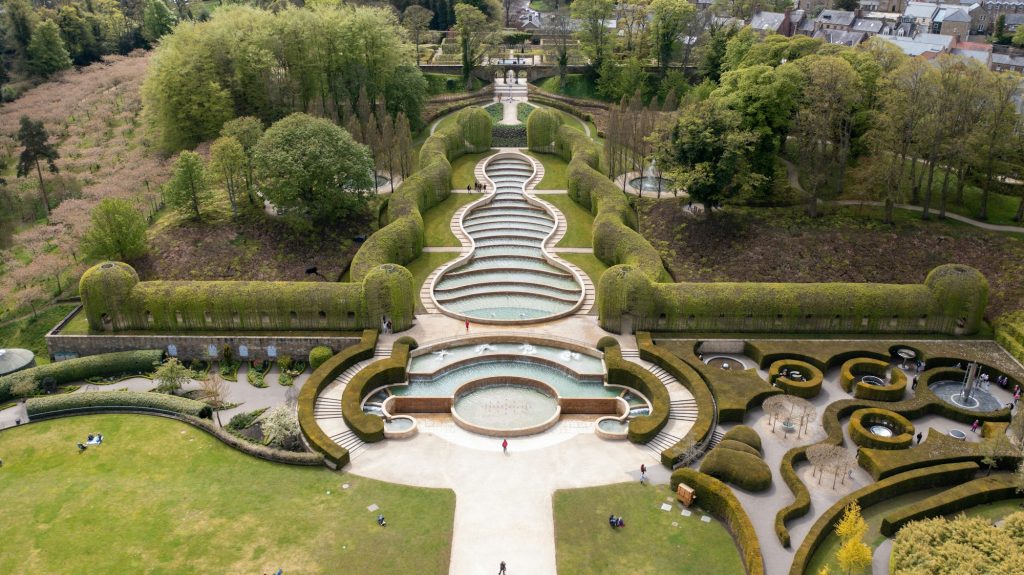 Alnwick gardens from above filled with people and trees